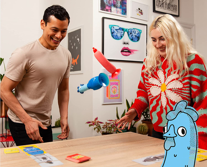 Two players engaged in the Chicken vs Hotdog game, tossing a blue chicken and a red hotdog toy in the air