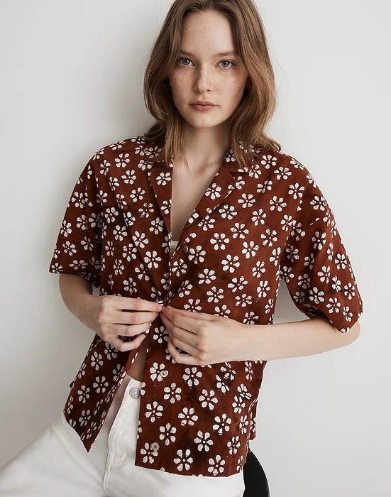 a model wearing the button-up shirt paired with white jeans