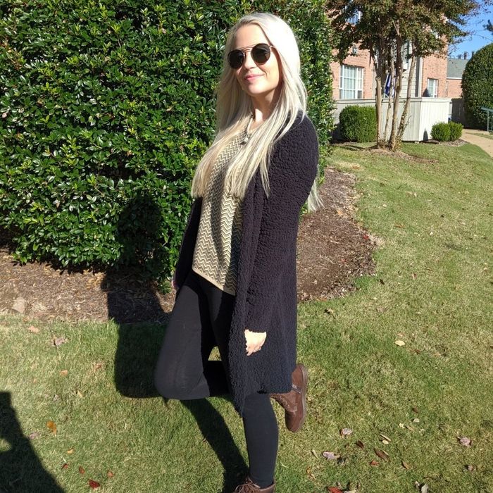 The reviewer is dressed in a classic black cardigan.