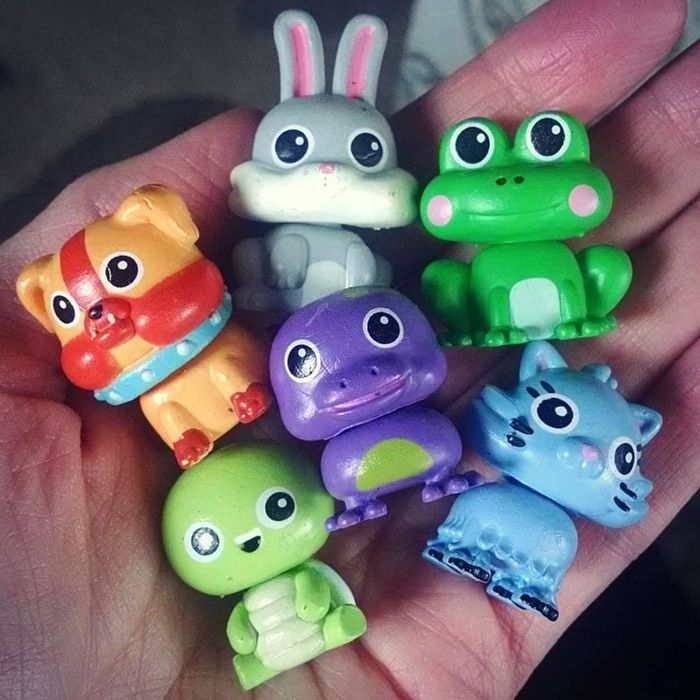 A reviewer holding the small animal figures hidden inside the foam balls, displaying the adorable toys.