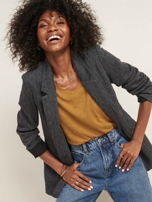 The model is dressed in an oversized herringbone tweed blazer.