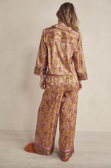 Model wearing gold and pink floral pajamas