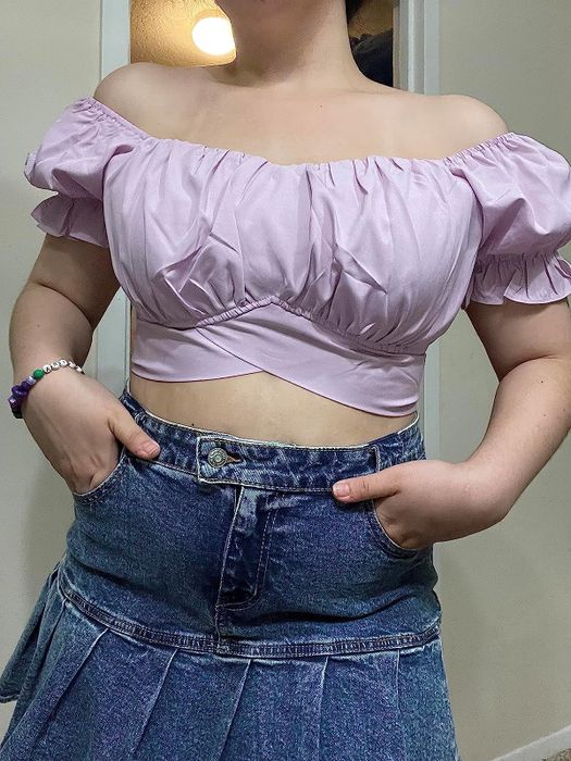 a reviewer sporting the lavender shirt with a high-waisted denim skirt