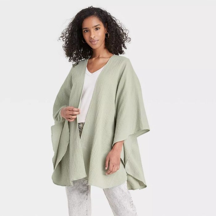 A model wearing a green wrap-style poncho.