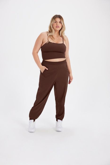 model wearing brown Summit Track Pants paired with a matching tank top