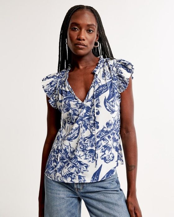 a model wearing the blouse with a blue and white print