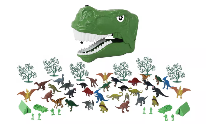 A green plastic dinosaur head case filled with smaller dino figures, trees, and camping gear