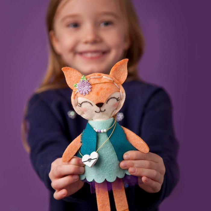 Child model holding a handmade felt fox plush