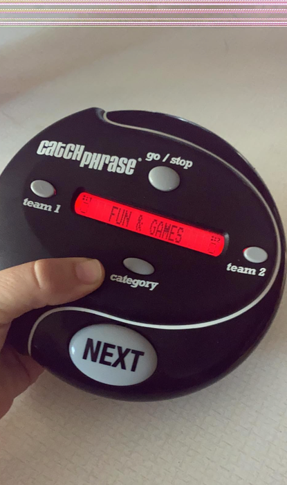 A hand holding an electronic device for the game