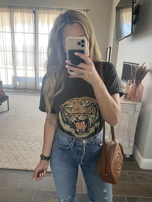 a reviewer showcasing the black version of the tiger tee