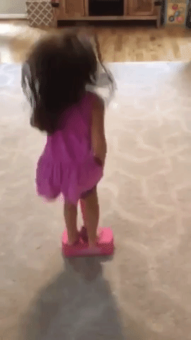 A reviewer's child bouncing on the pink pogo stick