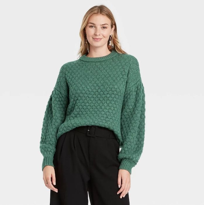 A model rocking a green textured sweater, looking effortlessly stylish.