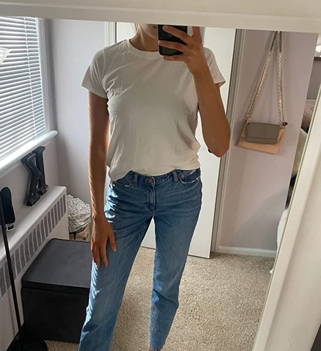 a reviewer modeling a short-sleeve white T-shirt