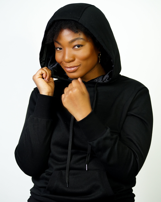 The model is wearing a black satin-lined Kin Apparel hoodie.
