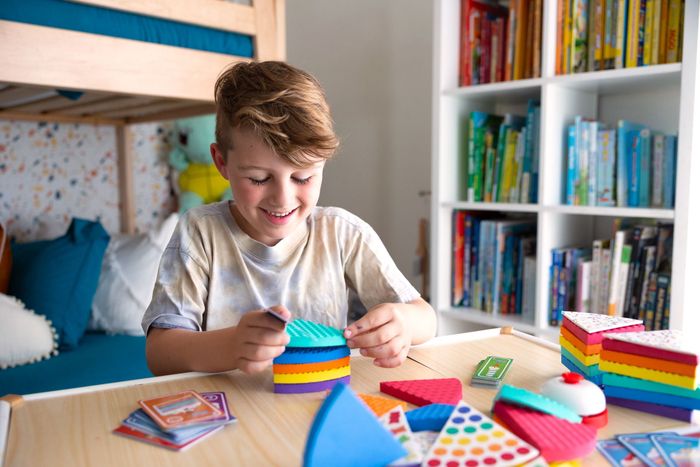 A child stacking colorful layers of cake in the game