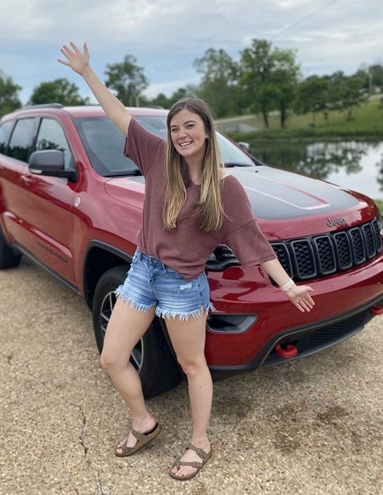 A reviewer wearing the burgundy waffle-knit top paired with denim shorts.