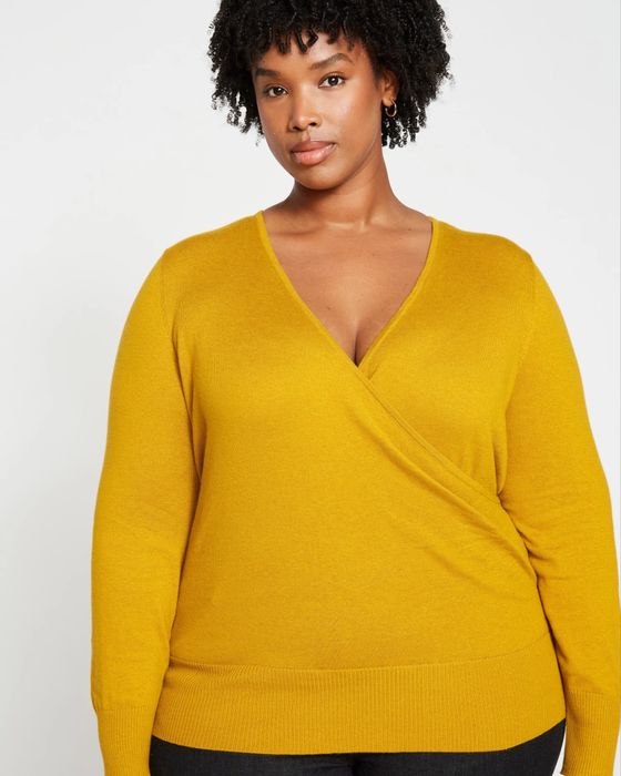 A model wearing a yellow wrap sweater.