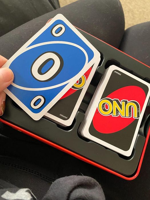 A reviewer's opened Uno game tin