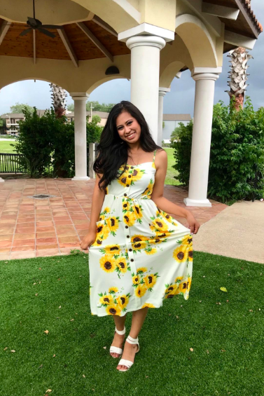A reviewer wearing the button-front dress in white with a sunflower print