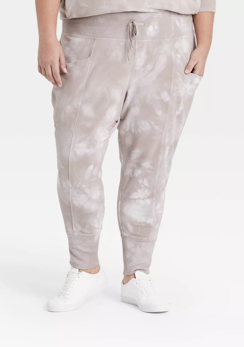 A model is wearing the joggers in a cool gray tie-dye design.