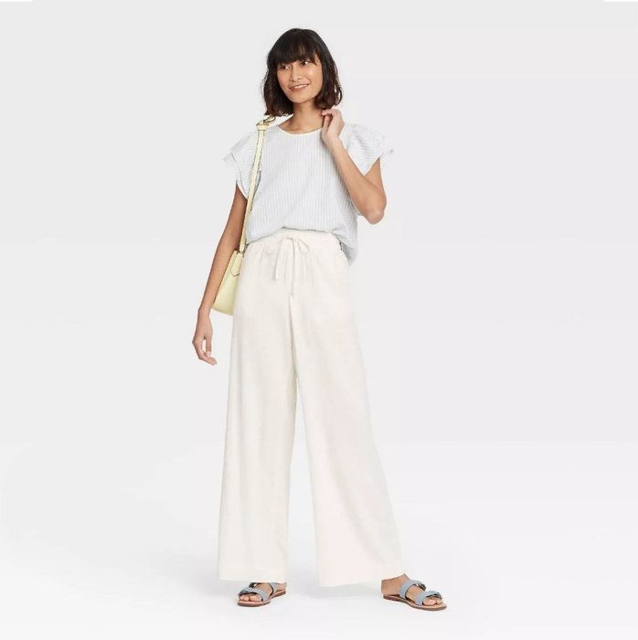 A model wearing the pants in a soft cream color, perfect for any casual outing.
