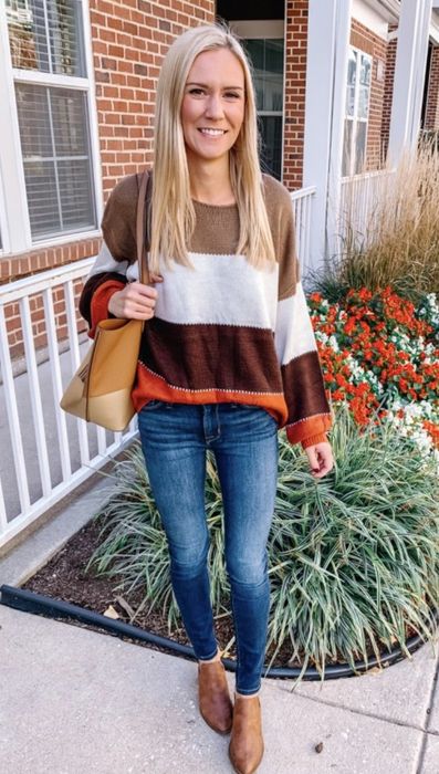 A pullover sweater featuring stripes in brown, orange, beige, and white.