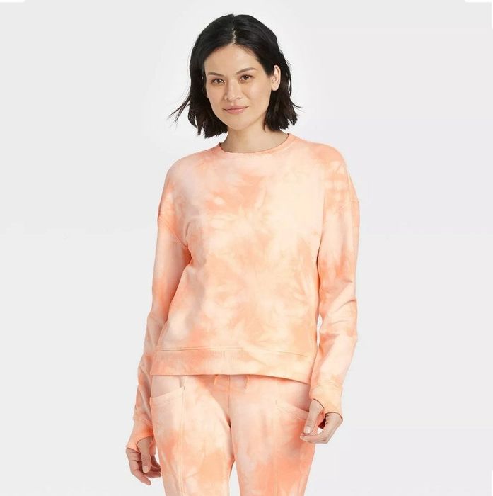 A model rocking an orange tie-dye crewneck paired perfectly with matching joggers.