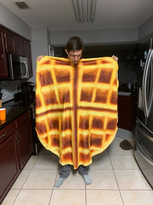 A reviewer holding the waffle blanket open