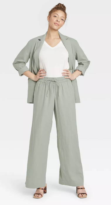 A model wearing the pants in a serene sage green, ideal for a fresh and calming look.