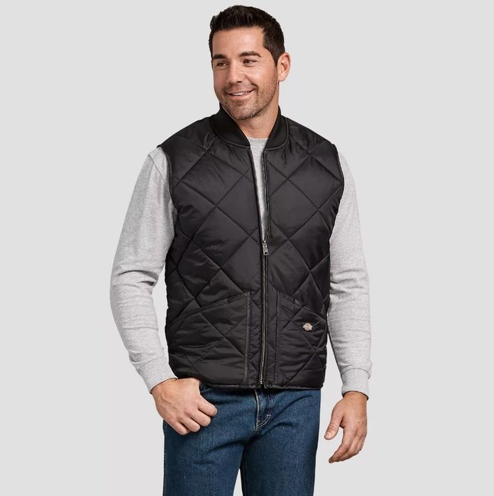 A model wearing a black nylon vest over a long-sleeve gray shirt.