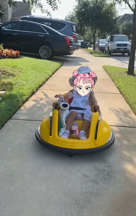 A child in the car with a stuffed animal, having fun outdoors on a sidewalk