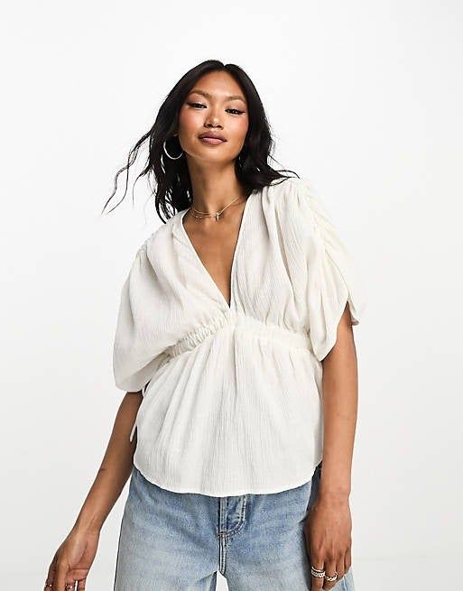 a model wearing the blouse in white