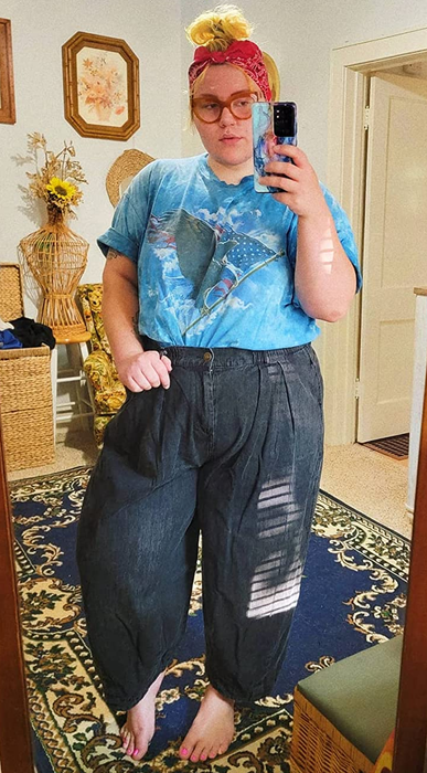 reviewer wearing the denim pants paired with a blue t-shirt