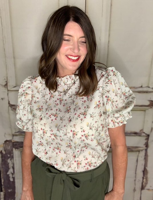a reviewer wearing the shirt in cream with a delicate floral print