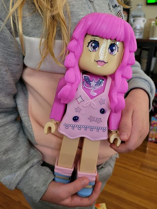 A child holding the Ava Star doll, ready to explore their creative side