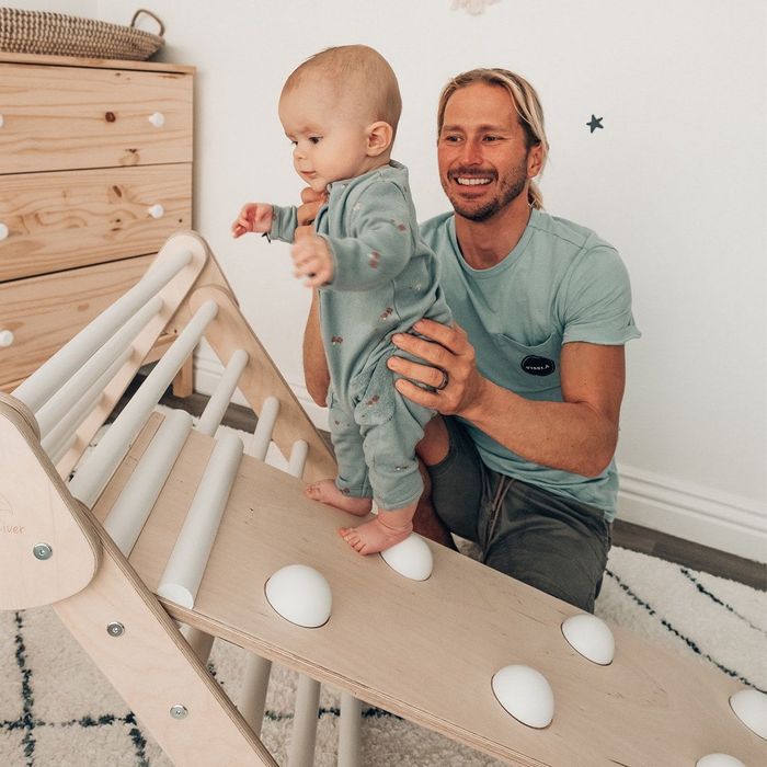 parent holding their baby on the climbing part
