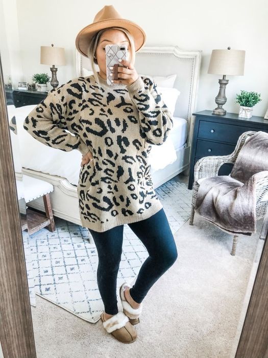 A reviewer wearing a tan and black leopard print sweater paired with leggings.