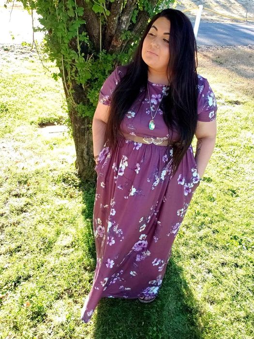 The reviewer is wearing a red floral short-sleeve dress.