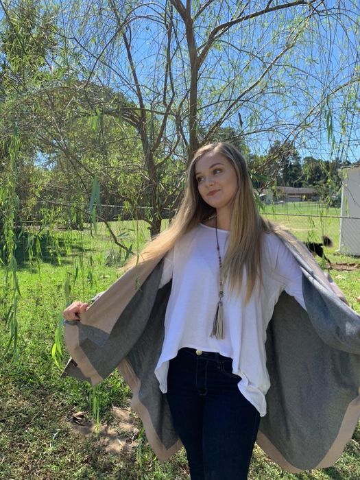 The reviewer is wearing the shawl draped over their shoulders with their arms stretched out.