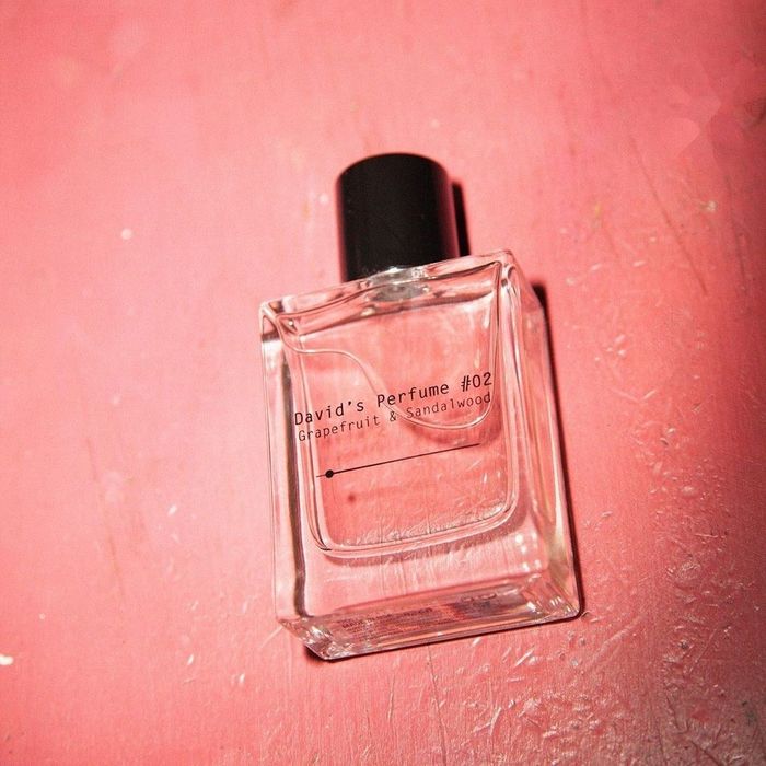 A clear perfume bottle filled with pink fragrance.