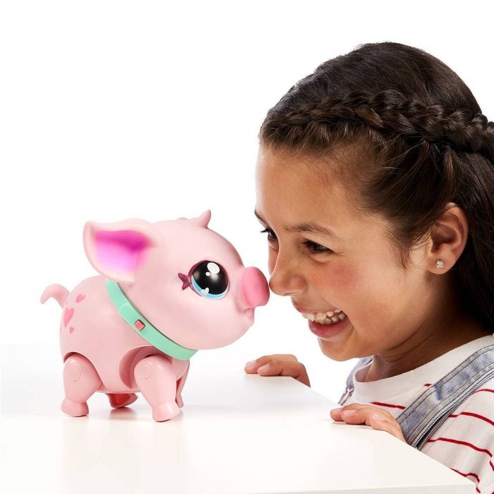 a child nuzzling the mini pig with their nose