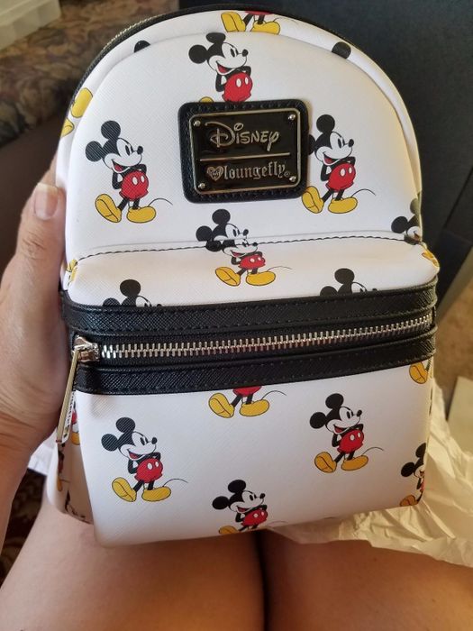 A white backpack adorned with an all-over Mickey Mouse print.