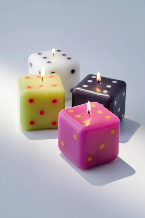 dice-shaped candles in black, white, pink, and yellow hues