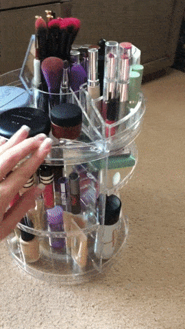 A GIF of a reviewer spinning the makeup organizer to showcase a full 360-degree view of its sleek design.