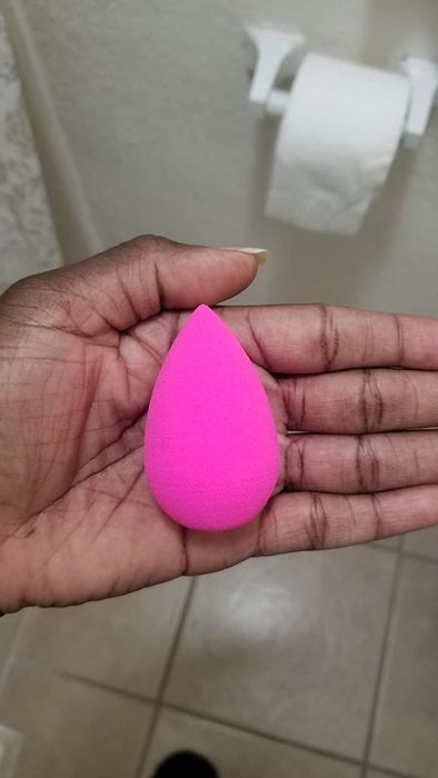 A reviewer holding up the beauty blender.