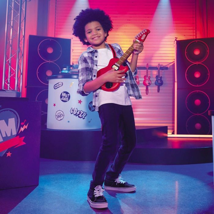 a child strumming the electric guitar, fully immersed in their mini jam session