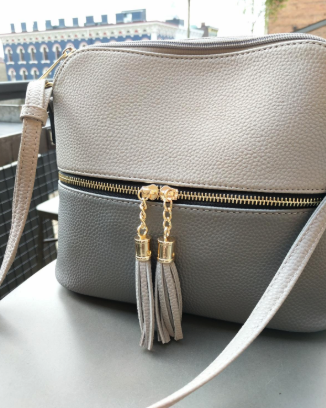 A reviewer's photo of a bag featuring a half white and half gray design, showcasing its modern and sleek style.