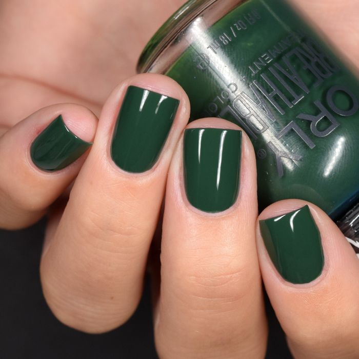 A model showcasing the green nail polish while holding the bottle.