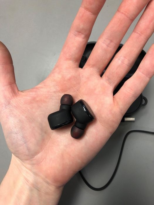 Reviewer holding the wireless earbuds