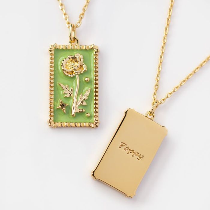 A rectangular pendant featuring a green background and a poppy flower design.